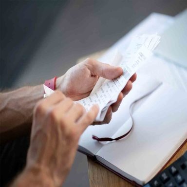 Close up of businessman holding bills while studying expenses