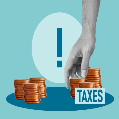 Tax increase concept with hand taking coins from stack labeled taxes, higher taxes and rising financial burden, government policy impact on personal income, budget pressure and economic challenge idea